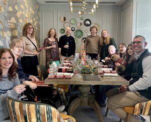 A family sat around a table celebrating christmas with christmas crackers at Haddenham Park Care Home in Buckinghamshire.