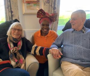 Two residents and a team member smiling together at Milton Ernest Hall in Bedfordshire.