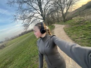 a girl walking with headphones on her head at Majesticare Luxury Care Homes.