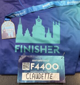 a t-shirt, a sign and a medal stating the oxford half marathon.